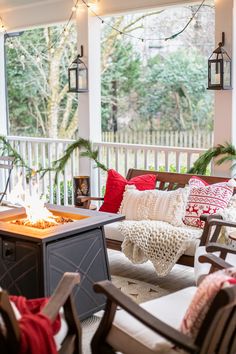 a porch with chairs, fire pit and christmas decorations