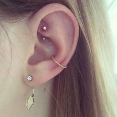 a woman's ear with two piercings on it