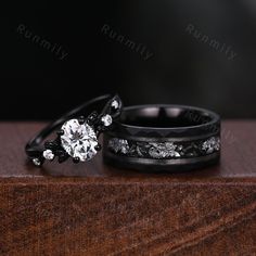 two black wedding bands with white diamond rings on top of each other in front of a dark background