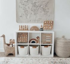 a white shelf with baskets and toys on it in front of a world map wall hanging