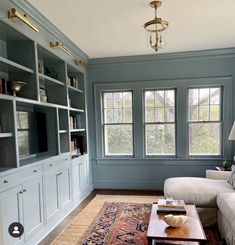 a living room filled with furniture and lots of windows