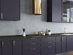 a kitchen with purple cabinets and gold accents