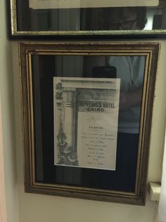 an old hotel sign is hanging on the wall next to a framed poster that says imperial hotel