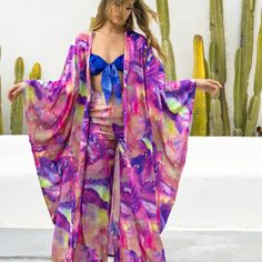 Introducing our fabulous long silky and gorgeous Blossom Kimono - the epitome of versatility! Whether you're hitting the marina scene or painting the town fuchsia at the coolest music festival, this beauty's got you covered. The print gracing this garment is a stunning abstract flower design, from our special partnership with the talented artist Mari Munet, who was stirred by the cherished tokens of a summer romance. Wear it over the Loto Maillot, with the coordinated Blossom Pant or just to surround yourself in self-love indulgence over your trusted jeans with heal slingbacks. Embrace the chic, relaxed vibes, and let your style bloom effortlessly. Color Fucsia, Summer Romance, Abstract Flower, Slingbacks, Abstract Flowers, The Chic, Flower Design, Music Festival, Good Music