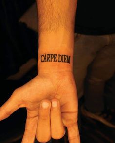 a person's hand with a tattoo that reads carpe diem