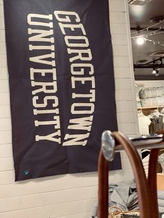 a black and white banner hanging on the wall next to a chair in a room