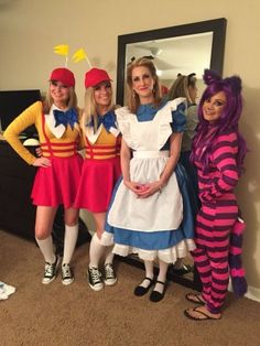 three women dressed in costumes standing next to each other