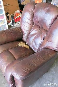 a brown recliner chair sitting on top of a floor next to a pile of boxes