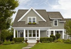 a house with a red front door and white trim on the windows is shown in this image