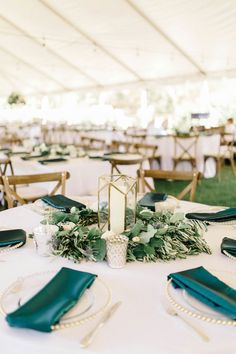 the tables are set up with green napkins and place settings for an elegant wedding reception