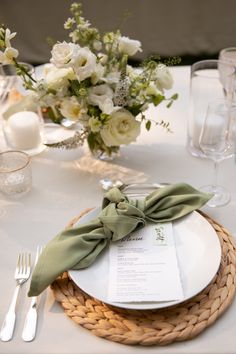 a place setting with napkins, silverware and flowers