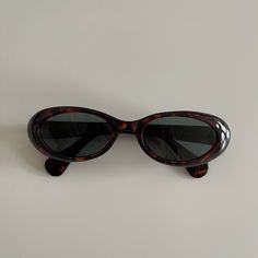 These round oval sunglasses are your everyday classic frames.  Featuring a brown tortoise frame with a smoke lens.  This style is unisex.  True genuine vintage sunglasses from the 90s.   - 400 uv  - new vintage from the 90s -Material: polyurethane frame , steel arms embedded within frame and glass lens Measurements:  Frame width: 147mm Lens Height: 30mm  Lens Width: 51mm  Bridge: 17mm  Arm temple: 140mm - includes sunglasses pouch also available in black 90s Sunglasses Aesthetic, Vintage Shoes Aesthetic, 90s Sunglasses Vintage, Oval Sunglasses 90s, Glasses Inspo, Brown Items, Vintage Round Sunglasses, Aesthetic Sunglasses, Sunglasses Aesthetic