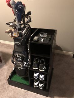 a golf bag and several pairs of shoes are on display in the corner of a room