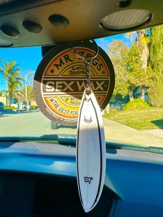 a surfboard hanging from the dashboard of a car in front of a street sign