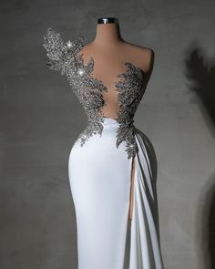 the back of a white dress with silver sequins on it