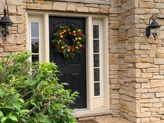 a black front door with a wreath on it