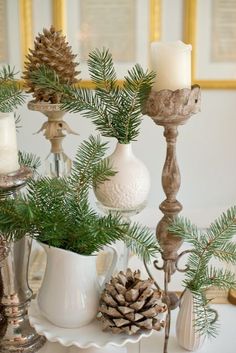 pine cones, candles and other christmas decorations on a white tray with gold trimmings