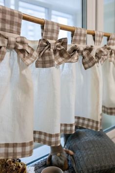 the kitchen is decorated with gingham checkered curtains and decorative dishes on the counter