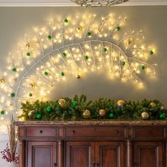 christmas lights decorate the top of a buffet in a room with wood paneling and white walls