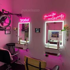 a hair salon with pink lighting and chairs in front of the mirrors that have neon lights on them