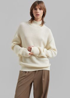 Color: Ecru Midweight wool blend fabric Relaxed fit Turtleneck Drop shoulders Rib knit Slip on style 50% Wool 50% Acrylic Dry Clean By Amomento. Imported Beige Textured Wool Sweater, White Textured Knit Cashmere Sweater, Beige Merino Wool Sweater With Textured Knit, Beige Merino Wool Turtleneck For Fall, White Merino Wool Sweater For Fall, Beige Textured Knit Merino Wool Sweater, Beige Textured Merino Wool Sweater, White Wool Polo Sweater For Fall, White Wool Polo Sweater For Winter