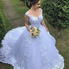 a woman in a blue wedding dress is standing outside