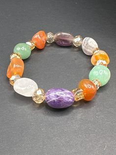 This beautifully crafted beaded bracelet features an array of healing crystals, including amethyst, rose quartz, carnelian, and green aventurine. Each gemstone is thoughtfully chosen for its unique properties to help support your emotional and spiritual well-being. Amethyst promotes peace, clarity, and balance, while rose quartz encourages love and compassion. Carnelian is the stone of motivation and creativity, giving you the confidence to pursue your passions. Green aventurine is known for attracting luck, new opportunities, and positive change. With its vibrant beads and subtle elegance, this bracelet is perfect for adding a touch of energy and color to any outfit. The handcrafted design makes it comfortable for everyday wear or as a statement piece. Whether you're looking for healing e Healing Carnelian Beaded Bracelets With Natural Stones, Bohemian Aventurine Crystal Bracelet With Gemstone Beads, Bohemian Aventurine Bracelet With Gemstone Beads, Multicolor Amethyst Natural Stones Bracelet, Multicolor Amethyst Gemstone Beaded Bracelets, Multicolor Amethyst Beaded Bracelets With Natural Stones, Multicolor Amethyst Bracelets With Natural Stones, Multicolor Crystal Bracelet With Natural Stones For Healing, Multicolor Amethyst Gemstones For Healing