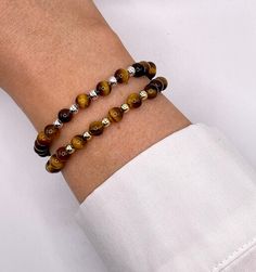 Handmade 6mm Tigers Eye gemstone and Sterling Silver or 14k gold filled beaded bracelets. The beads are threaded and secured onto high quality jewellers stretch elastic and are perfect for stacking and layering. These bracelets are made from high quality 14k gold filled beads (not plated) if looked after correctly these bracelets will not tarnish. Tigers Eye helps to improve confidence and bring good luck and prosperity to the wearer. It increases bravery and courage to those facing difficult si Gold Tiger Eye, Crystal Healing Bracelets, Tigers Eye Gemstone, Tiger Eye Beads, Healing Bracelets, Nature Bracelets, Beaded Stretch Bracelet, Tiger Eye, Gemstone Bracelet