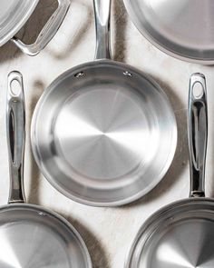 several stainless steel pans and spatulas on a table