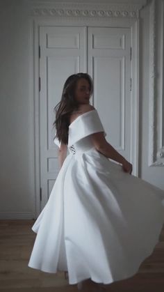 a woman in a white dress is posing for the camera