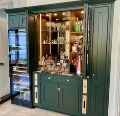 a green cabinet filled with lots of bottles and glasses