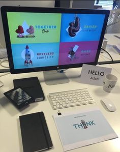 a desktop computer sitting on top of a white desk next to a keyboard and mouse