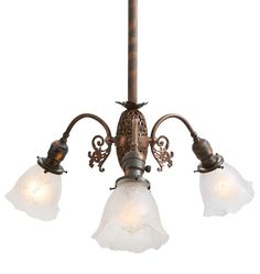 three light chandelier with frosted glass shades on an old - fashioned ceiling fixture