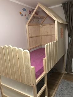 there is a bunk bed with a purple blanket on it and a wooden ladder to the bottom