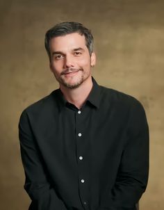 a man in black shirt posing for a photo