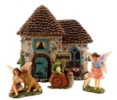 the figurines have been placed in front of the small house with fairy figures