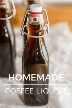 homemade coffee liqueur in glass bottles sitting on a white tablecloth with the words homemade coffee liqueur above it