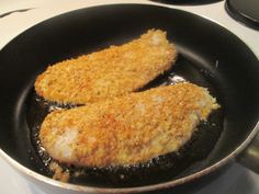 two pieces of chicken cooking in a frying pan on top of a stovetop