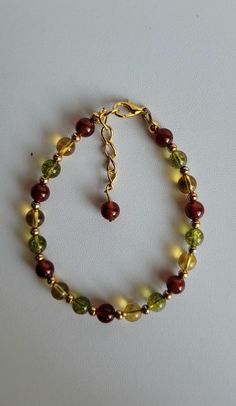 This Fall colored bracelet has 3 different gemstones with Gold-plated brass beads and findings. They are Carnelian, Citrine and Peridot. The bracelet has a 1" extension with a beaded drop and lobster claw clasp.  Custom orders are welcome! Ask about free sizing. Hand-strung Gold Jewelry With Czech Glass, Hand-strung Gold Czech Glass Jewelry, Gold Czech Glass Jewelry, Hand-strung, Amber Bracelet For Healing, Amber Healing Bracelet Jewelry, Adjustable Amber Gemstone Bracelets, Gold Rosary Bracelet With Natural Stones And Round Beads, Gold Bracelets With Polished Beads For Healing, Adjustable Natural Stones Bracelet