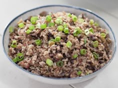 a bowl filled with brown rice and green onions