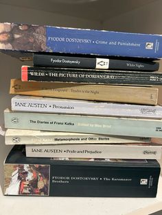 a stack of books sitting on top of a white shelf