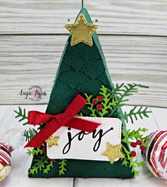 an ornament with the word joy on it next to christmas decorations and ornaments