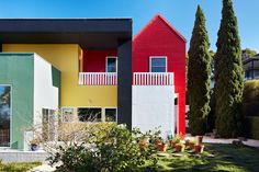 two houses are painted bright colors in the yard