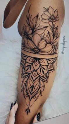 a woman's thigh with flowers on it and a ribbon tied around the leg