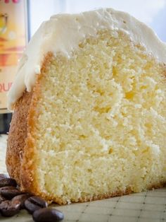 a piece of cake sitting on top of a counter next to coffee beans and a bottle