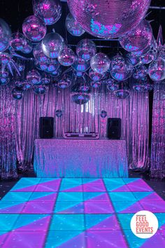 the dance floor is covered in purple and blue disco ball decorations for a wedding reception