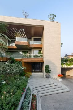 an apartment building with plants and flowers in the front yard