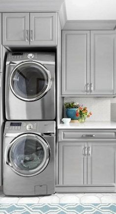 a laundry room with washers and dryers stacked on top of eachother