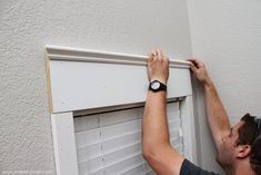 a man working on an air conditioner with his watch hanging off the side of it