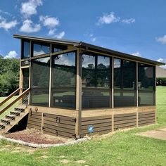 a small wooden building sitting on top of a lush green field